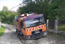 CA-N FILMELE CU PROȘTI: Mașină de gunoi îngropată în noroi, pe o stradă din Sighet (galerie foto)